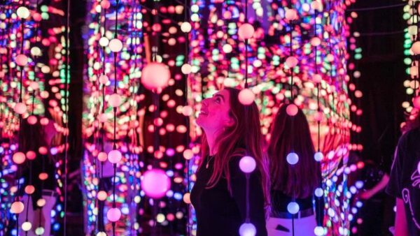 Visitante explora ambiente iluminado da Dopamine Land no Shopping Eldorado