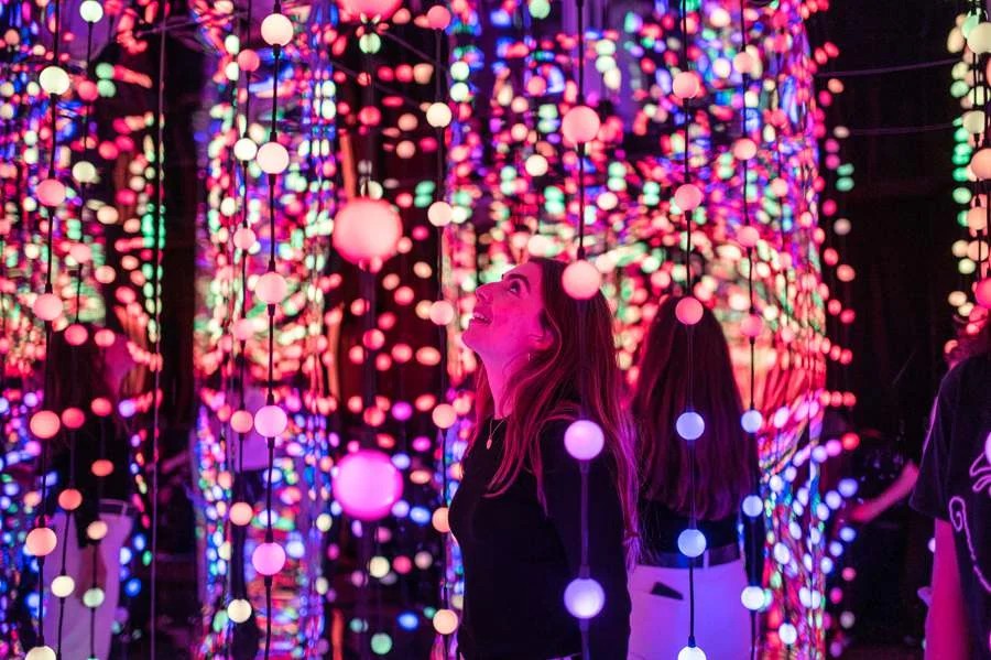 Visitante explora ambiente iluminado da Dopamine Land no Shopping Eldorado