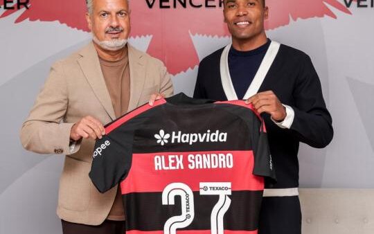 Alex Sandro posa com a camisa do Flamengo ao lado de dirigente do clube após renovar contrato