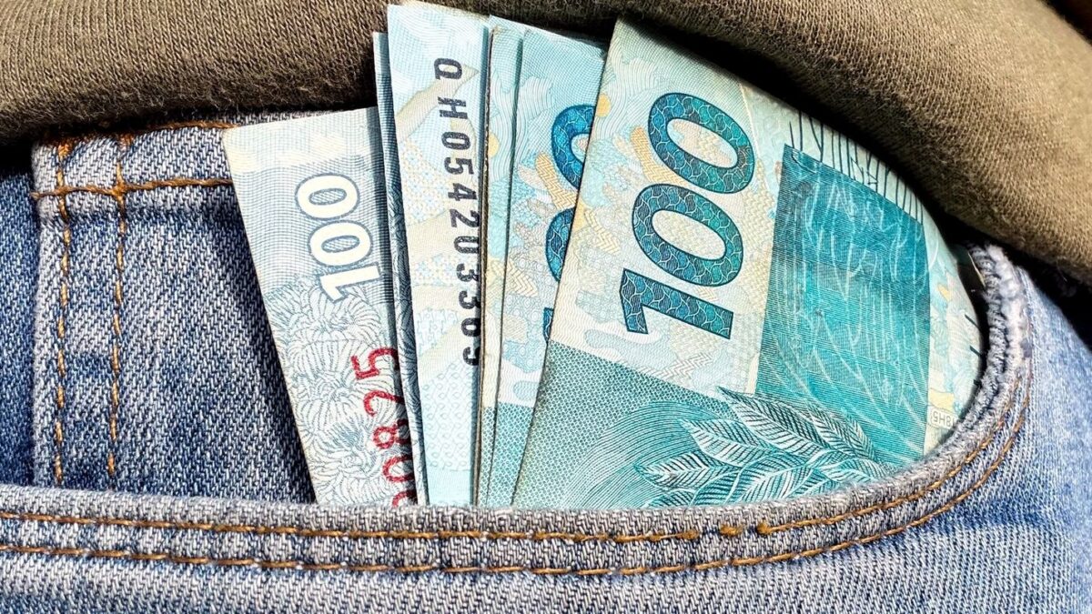 Notas de cem reais no bolso, ilustrando distribuição de lucros do FGTS