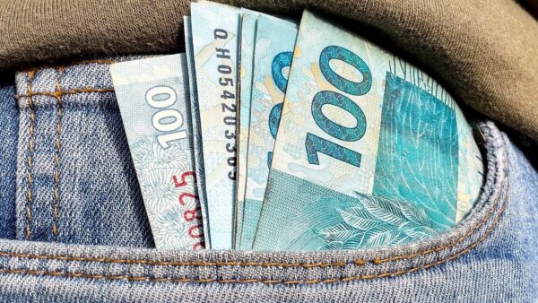Notas de cem reais no bolso, ilustrando distribuição de lucros do FGTS