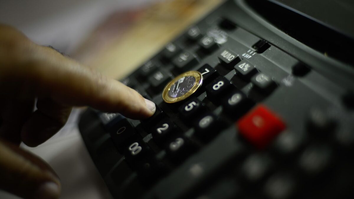 Calculadora com moeda de real, ilustrando cálculo de inflação