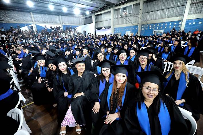 Formandos com beca e capelo durante cerimônia de formatura da Fundação Florestan Fernandes em Diadema