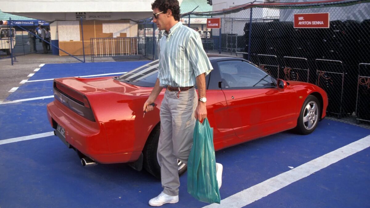 Ayrton Senna ao lado do seu Honda NSX vermelho no paddock