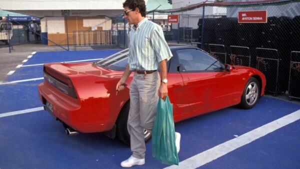 Ayrton Senna ao lado do seu Honda NSX vermelho no paddock
