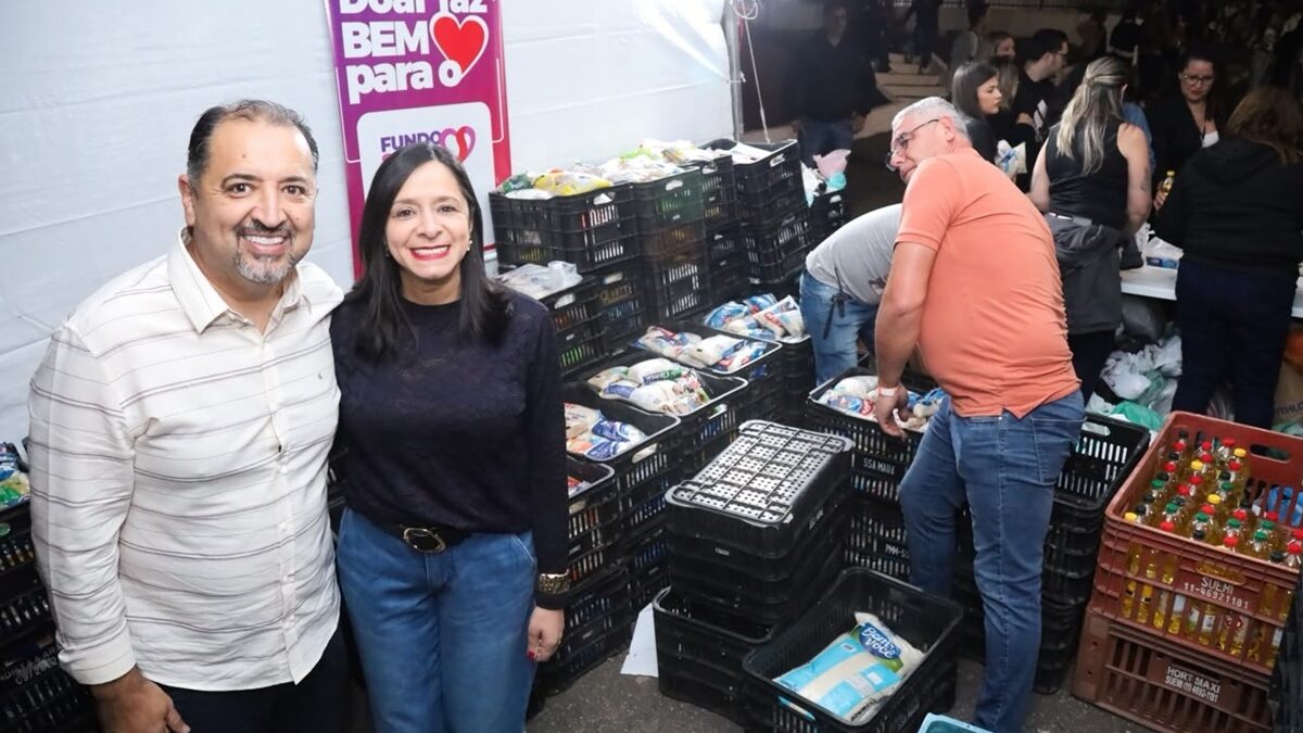 Representantes do Fundo Social de Mauá ao lado de caixas de alimentos arrecadados na Quermesse