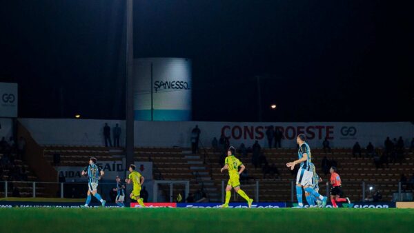 Jogadores de Mirassol e Grêmio em campo durante partida noturna pelo Brasileirão