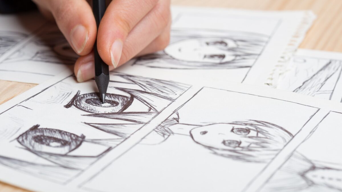 Mão desenhando quadrinhos em estilo mangá durante oficina cultural