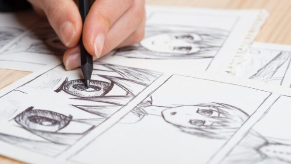 Mão desenhando quadrinhos em estilo mangá durante oficina cultural