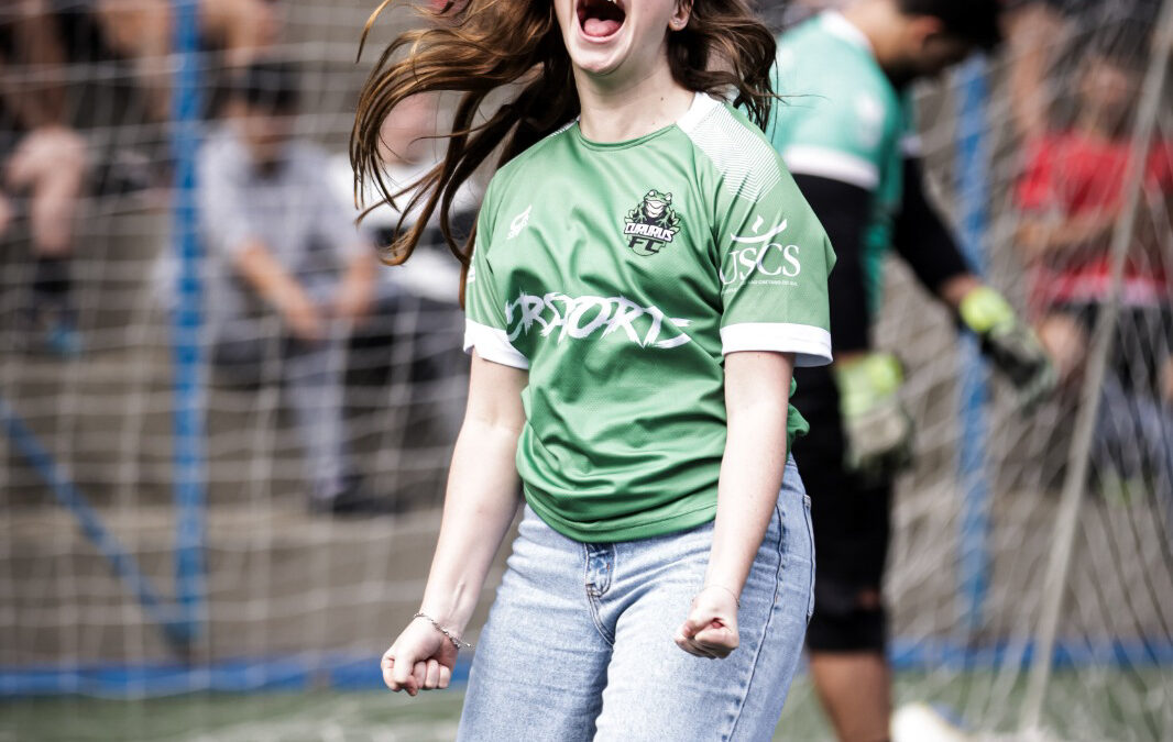 Torcedora comemora em campo de futebol durante evento esportivo