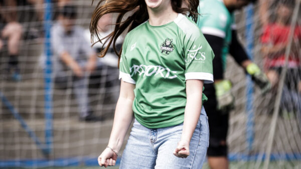 Torcedora comemora em campo de futebol durante evento esportivo