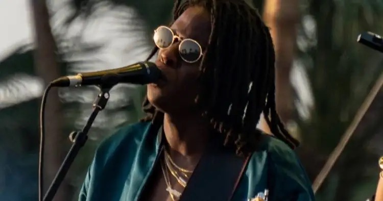 Daniel Caesar canta ao microfone durante apresentação ao ar livre
