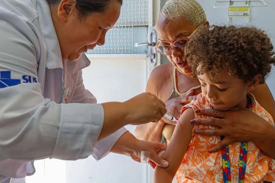 Profissional de saúde aplica vacina pneumo 20 em criança em Diadema