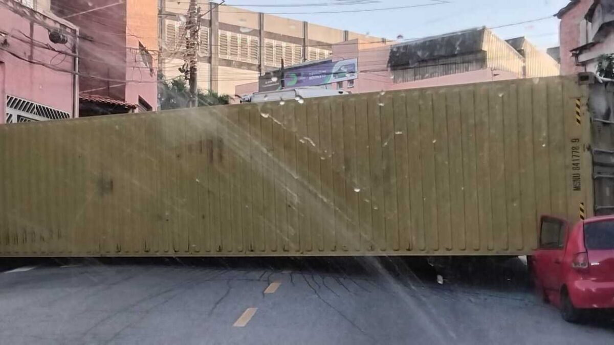 Contêiner de caminhão tombado sobre carro após acidente em ladeira no bairro Inamar em Diadema