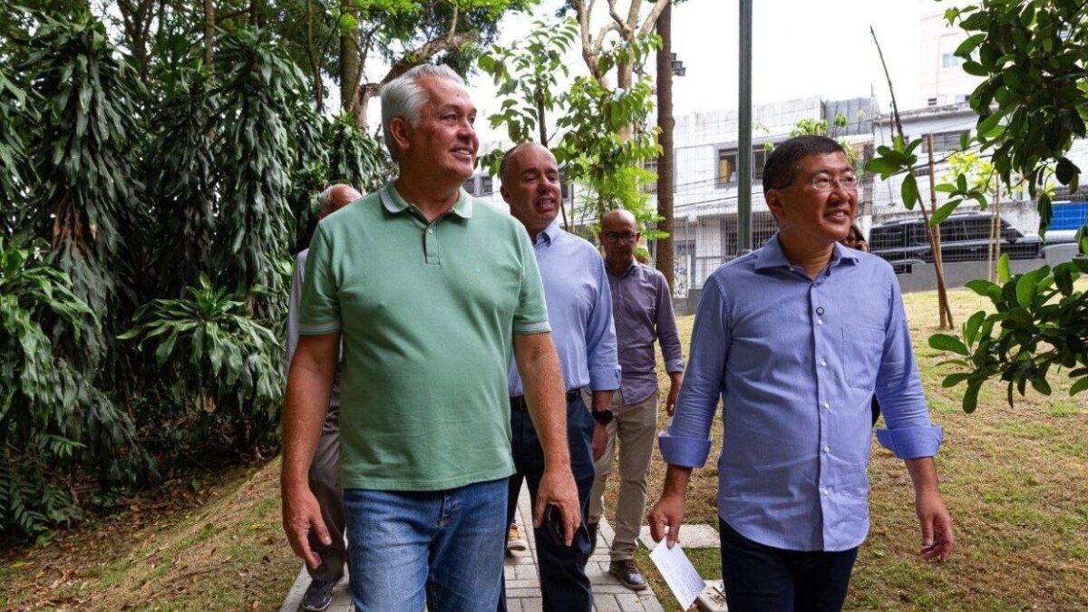 Marcos Michels caminhando ao lado do prefeito Taka Yamauchi e outras autoridades em área verde de Diadema