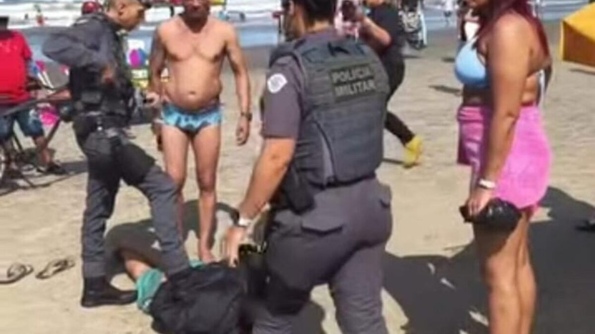 Policiais militares realizando prisão em flagrante na areia da praia em Praia Grande após ação da GCM de Diadema