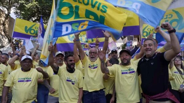 Apoiadores de Clóvis Volpi seguram bandeiras de campanha