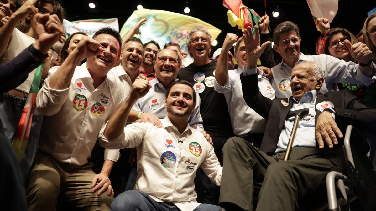 Gabriel Souza, Germano Rigotto e apoiadores comemorando em palco durante convenção do MDB no Rio Grande do Sul