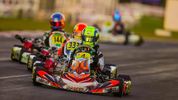 Pilotos de kart competem em pista de corrida