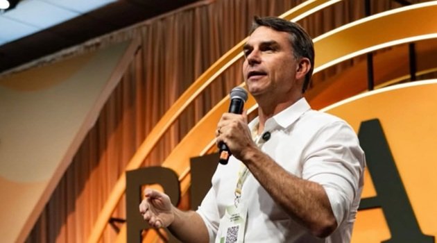 Flávio Bolsonaro discursa ao microfone em evento