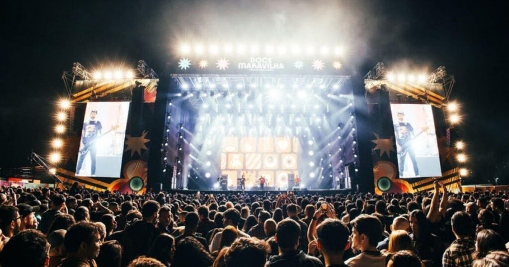 Multidão em frente ao palco iluminado do Festival Doce Maravilha no Jockey Club do Rio de Janeiro