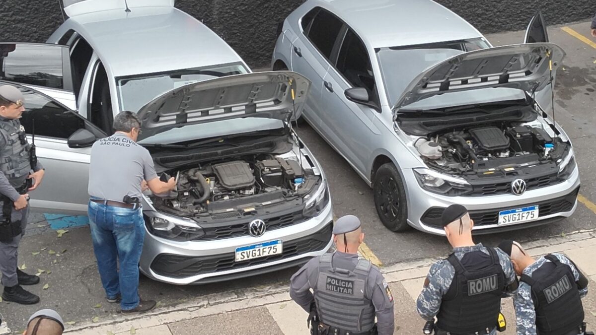 Policiais civis, militares e da ROMU cercam dois carros Volkswagen Polo idênticos apreendidos por clonagem de placa