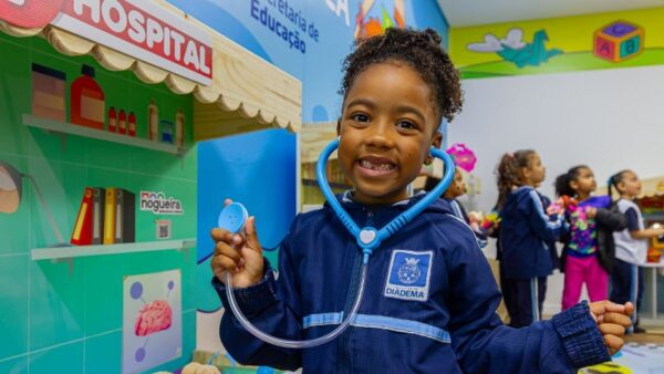 Criança com estetoscópio de brinquedo em espaço lúdico de unidade escolar de Diadema