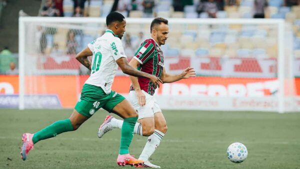 Jogador do Fluminense conduz a bola marcado por adversário do Palmeiras
