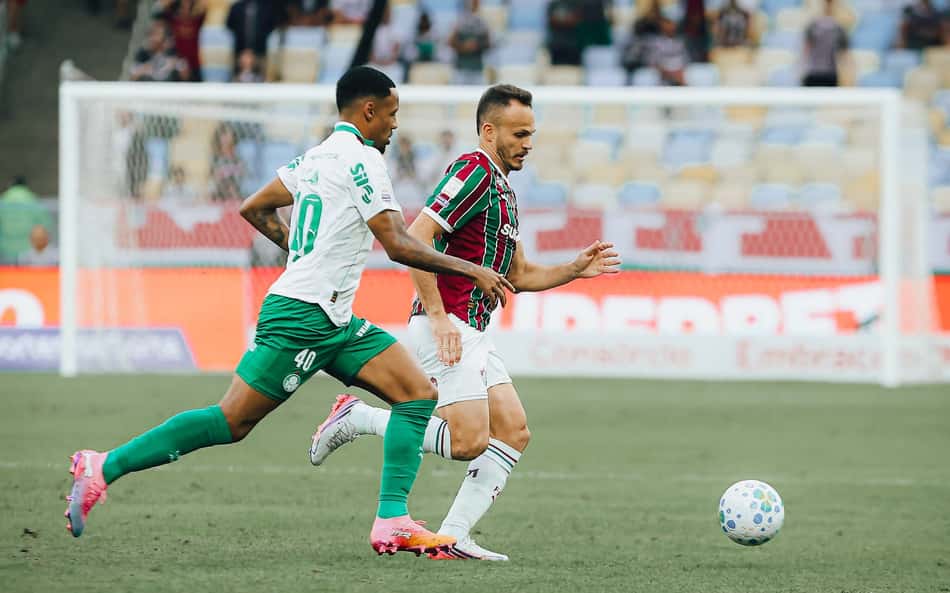 Jogador do Fluminense conduz a bola marcado por adversário do Palmeiras