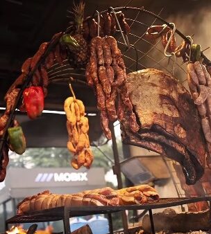 Carnes assadas penduradas em estação de churrasco do Burning Fest em São Bernardo