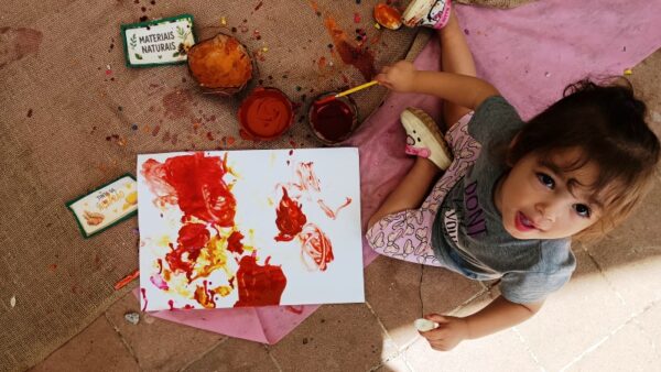 Menina pinta com tintas naturais durante o Encontro da Primeiríssima Infância em Diadema