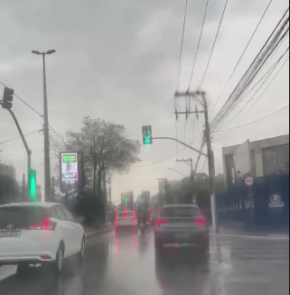 Rua com sinalização de trânsito e carros durante dia chuvoso no Bairro Fundação