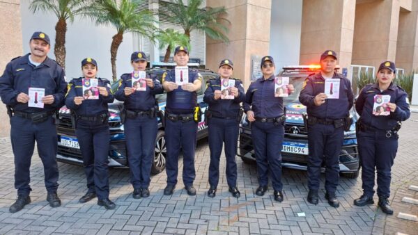 Equipe da Guardiã Maria da Penha da GCM de São Bernardo em frente a viaturas durante ação do Agosto Lilás