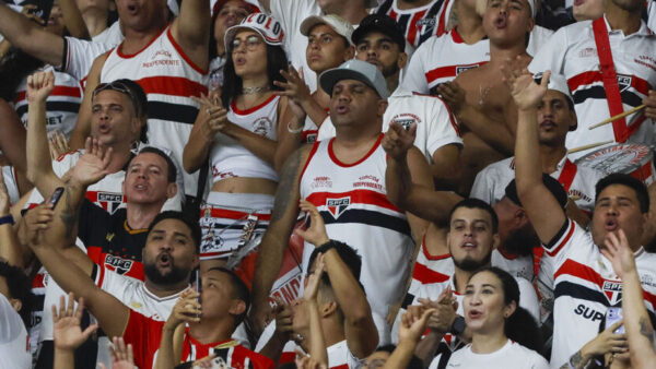 Torcida são-paulina com bandeiras e camisas em arquibancada de estádio