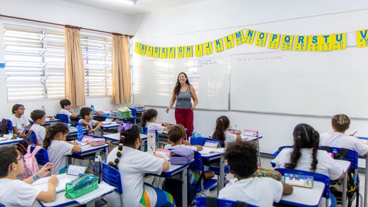 Professora sorri para alunos em sala de aula de escola municipal de São Bernardo