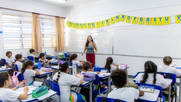 Professora sorri para alunos em sala de aula de escola municipal de São Bernardo