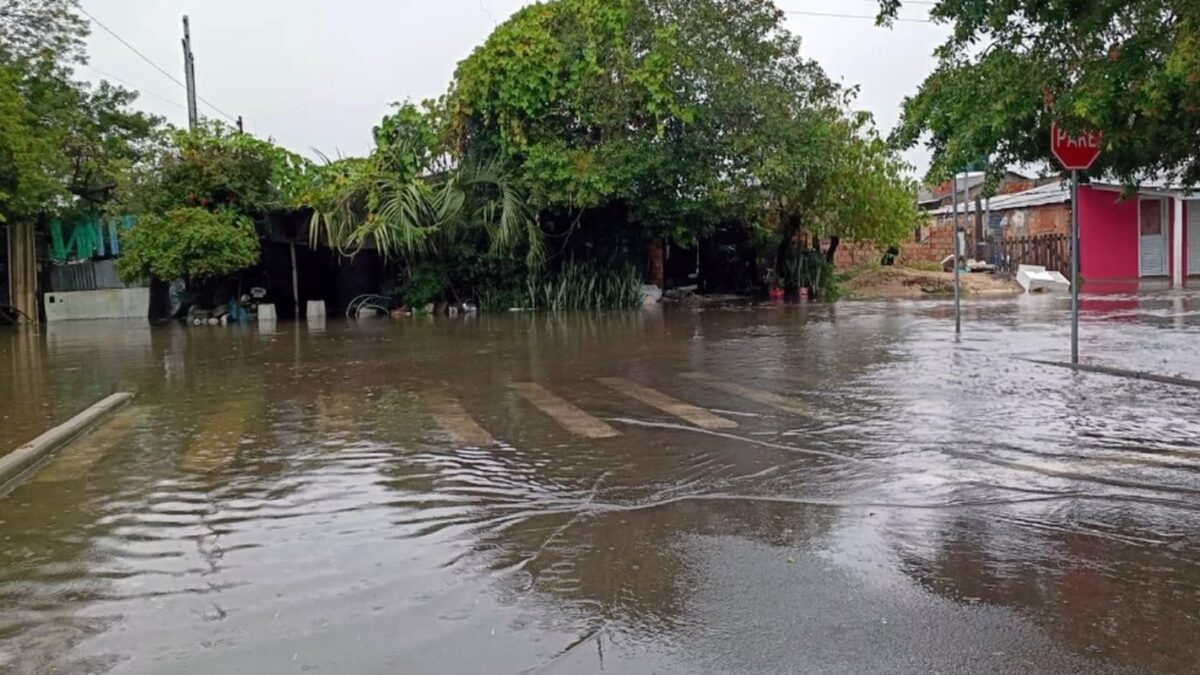 Rua residencial alagada com casas parcialmente submersas no Rio Grande do Sul