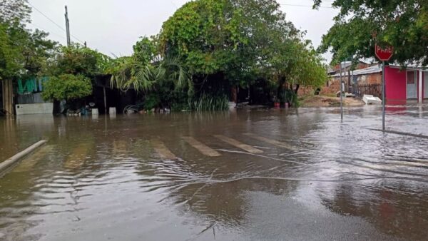 Rua residencial alagada com casas parcialmente submersas no Rio Grande do Sul