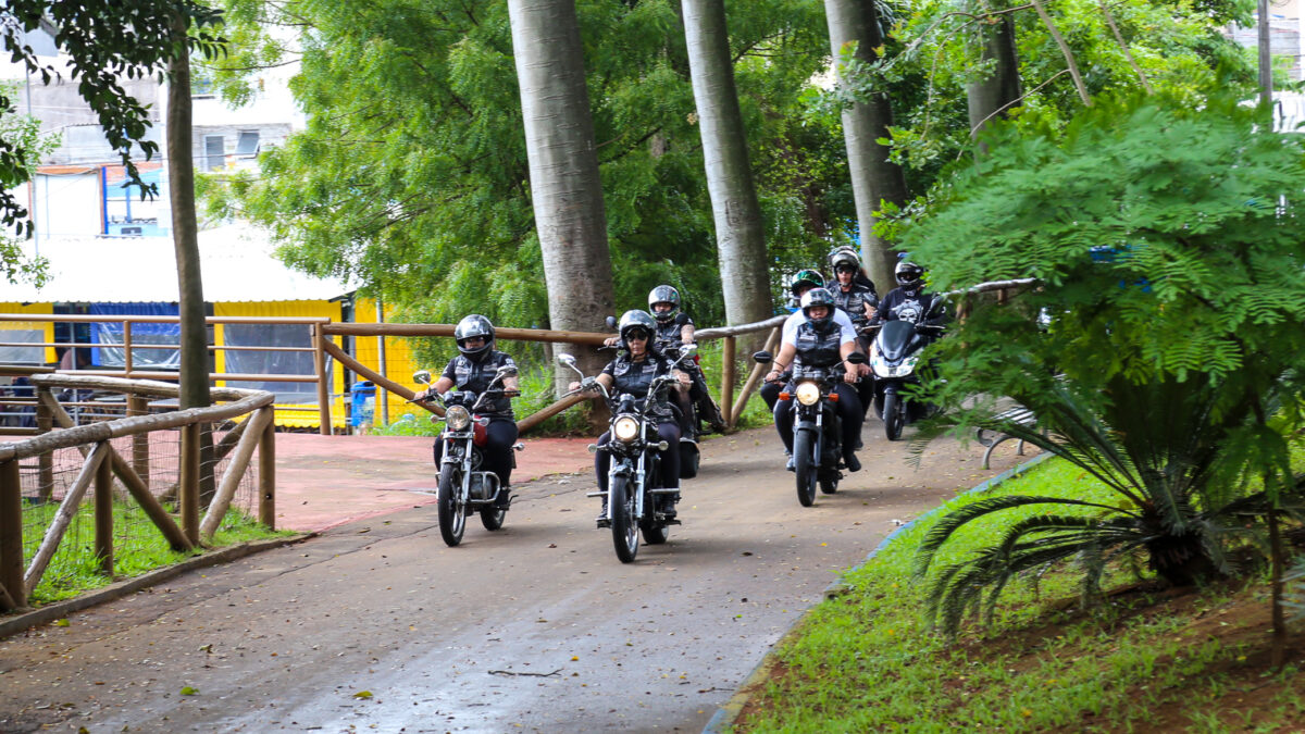 Motociclistas conduzem motos clássicas por alameda arborizada do Bosque do Povo