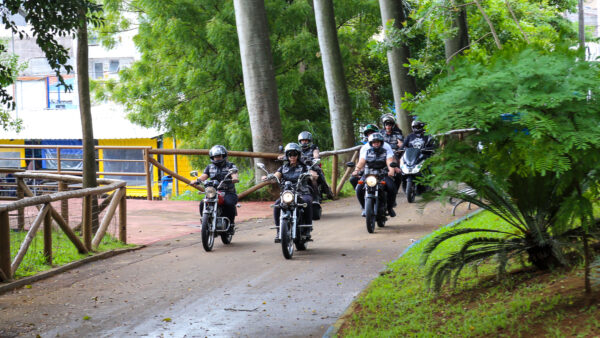 Motociclistas conduzem motos clássicas por alameda arborizada do Bosque do Povo