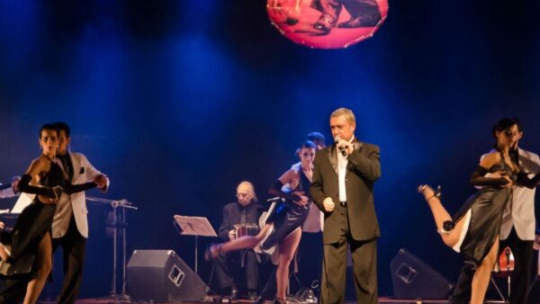 Bailarinos e cantor da Companhia Tango e Paixão se apresentam no palco