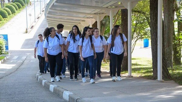 Estudantes caminham em fila com uniforme do Colégio Salvador Arena