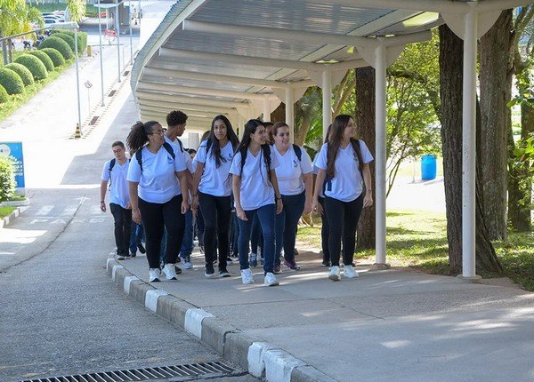 Estudantes caminham em fila com uniforme do Colégio Salvador Arena