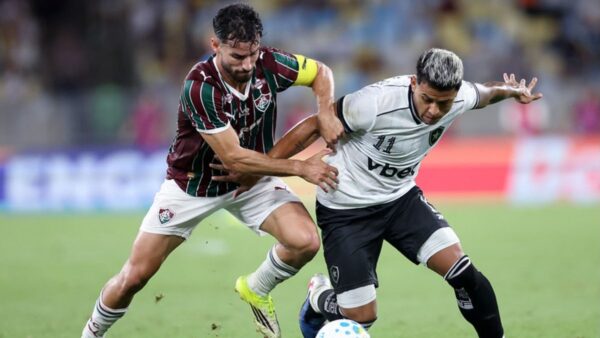 Jogadores de Botafogo e Fluminense disputam bola em clássico