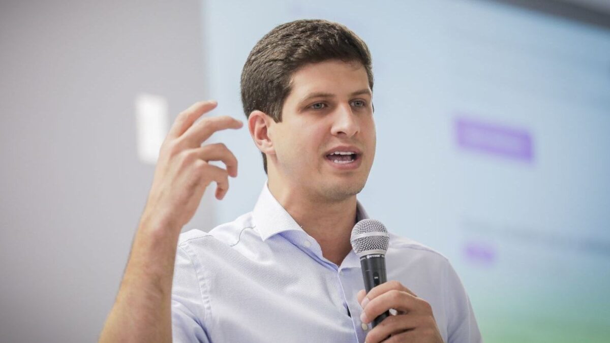 João Campos discursando ao microfone durante evento de campanha