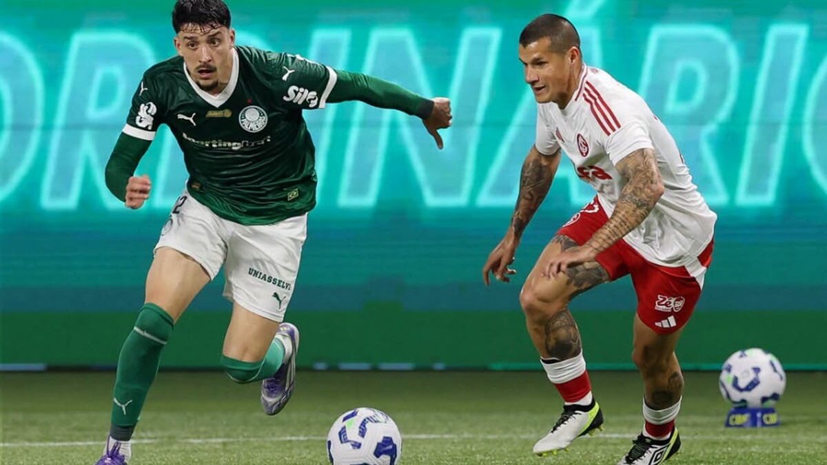 Jogador do Palmeiras conduz a bola disputando com adversário do Internacional