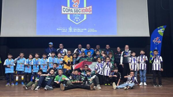 Crianças com medalhas no palco do Teatro Inezita Barroso na premiação da Copa SBC Kids de Futsal