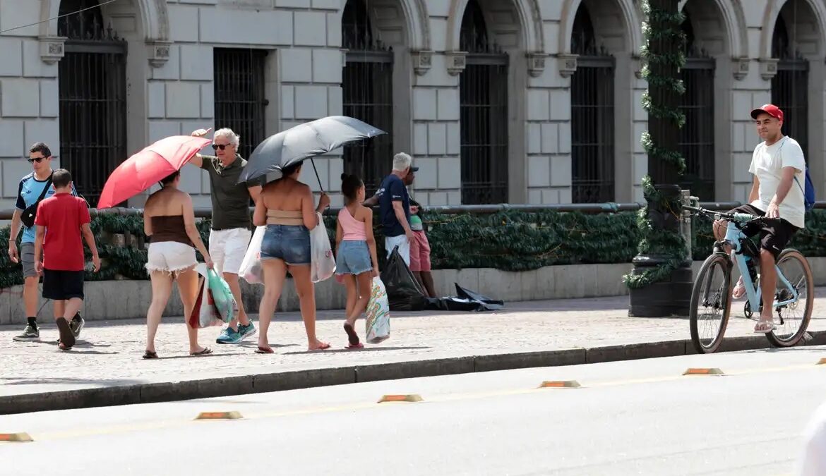 Pessoas com guarda-chuvas se protegem do sol durante onda de calor em São Paulo