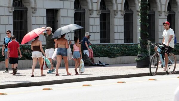Pessoas com guarda-chuvas se protegem do sol durante onda de calor em São Paulo