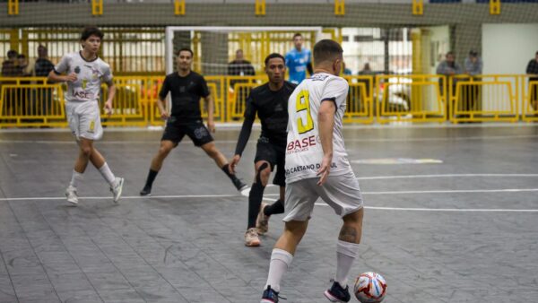 Jogador da Liga São Caetano conduz a bola em partida de futsal contra o Corinthians